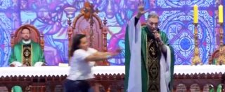Copertina di Il sacerdote sta celebrando la messa ma una donna sale sul palco e lo butta giù. E lui reagisce così