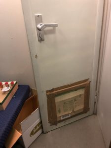 La porta rotta e riparata con un cartone