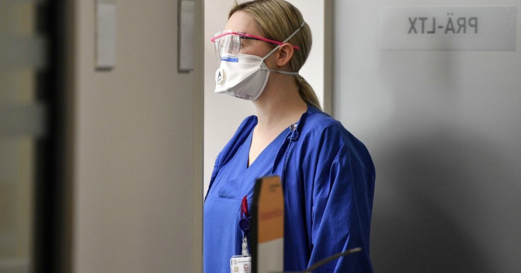 A nurse with a face mask to protect from coronavirus looks into a room during a presentation for media of new emergency rooms at the University Hospital in Essen, western Germany, Thursday, March 26, 2020. Hospitals in Germany ready themselves for an expected growing number of COVID-19 patients in the coming weeks. The new coronavirus causes mild or moderate symptoms for most people, but for some, especially older adults and people with existing health problems, it can cause more severe illness or death. (AP Photo/Martin Meissner) Coronavirus: Germania, boom di casi. In Spagna 4000 morti. Mille vittime in Usa, sindaco di New York: “Mezza città sarà contagiata”. Ma Oms dice: “Dall’Europa segnali incoraggianti”