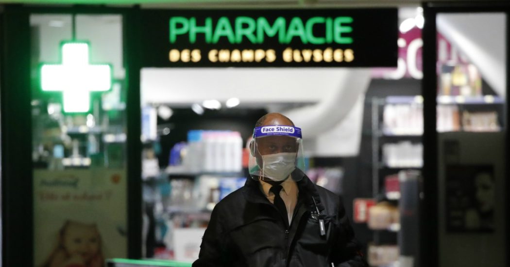 A security officer wearing a face shield and gloves stands in front a drugstore Monday, May 11, 2020 in Paris. The French began leaving their homes and apartments for the first time in two months without permission slips as the country cautiously lifted its lockdown. Clothing stores, coiffures and other businesses large and small were reopening on Monday _ with strict precautions to keep the coronavirus at bay. (AP Photo/Francois Mori)