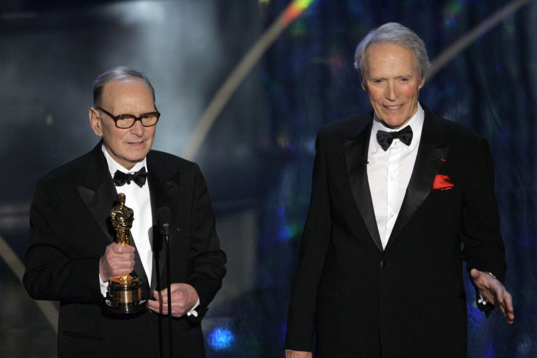 FILE – In this Feb. 25, 2007 file photo, Italian composer Ennio Morricone, left, accepts an honorary Oscar for his contributions to the art of film music as director Clint Eastwood looks on during the 79th Academy Awards telecast in Los Angeles. Morricone, who created the coyote-howl theme for the iconic Spaghetti Western “The Good, the Bad and the Ugly” and the soundtracks such classic Hollywood gangster movies as “The Untouchables,” died Monday, July 6, 2020 in a Rome hospital at the age of 91. (AP Photo/Mark J. Terrill, file)