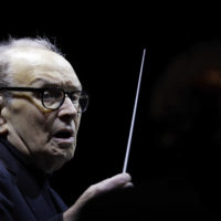 FILE – In this file photo dated Tuesday, March 6, 2018, Italian composer Ennio Morricone directs an ensemble during a concert of his "60 Year Of Music World Tour", in Milan, Italy. Morricone, who created the coyote-howl theme for the iconic Spaghetti Western “The Good, the Bad and the Ugly” and the soundtracks such classic Hollywood gangster movies as “The Untouchables,” died Monday, July 6, 2020 in a Rome hospital at the age of 91. (AP Photo/Luca Bruno, file)