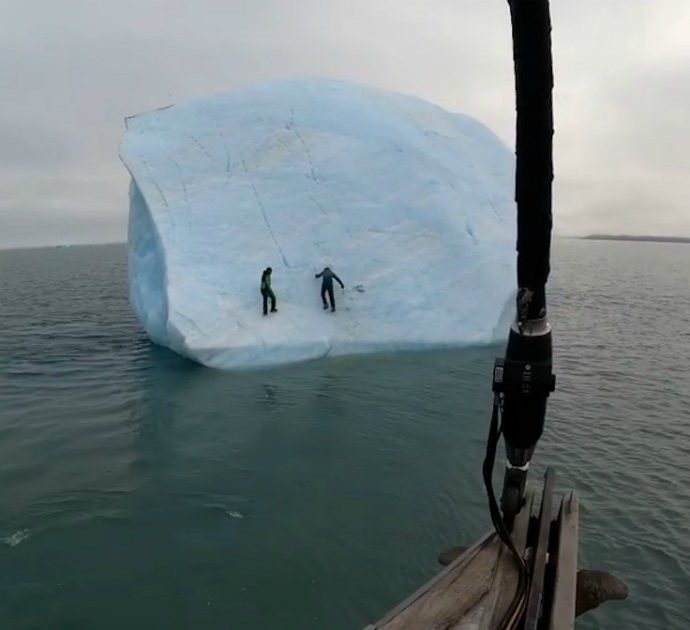 Due esploratori si arrampicano su un iceberg, ma qualcosa va storto: il blocco di ghiaccio sprofonda in mare – Video