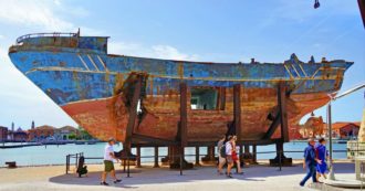 Copertina di Opera d’arte esposta alla Biennale di Venezia, ora relitto che nessuno vuole: braccio di ferro sulla barca della strage di migranti