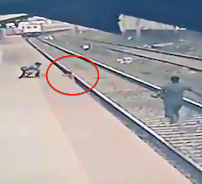Bambino cade sui binari mentre arriva il treno: il salvataggio è da brividi  – Video