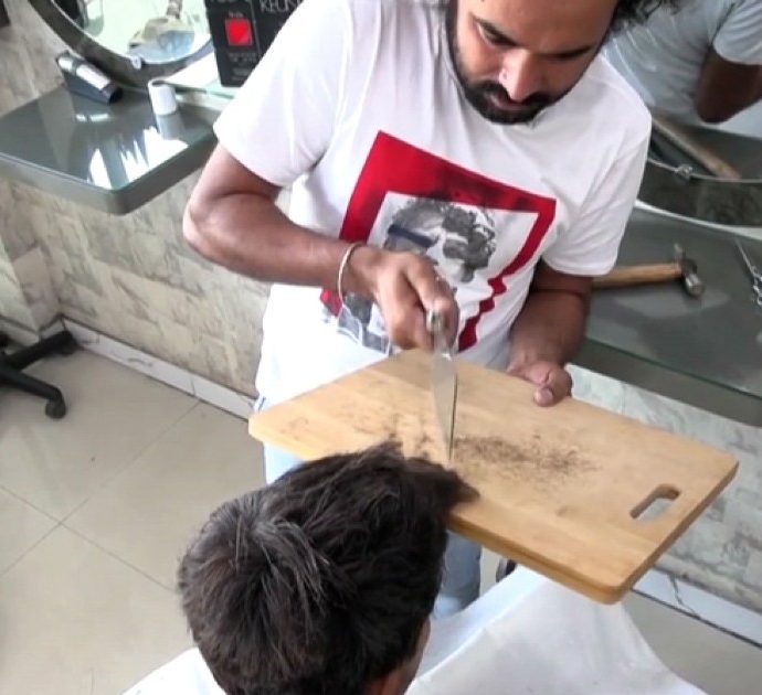 Fiamma ossidrica e mannaia: così il parrucchiere pakistano taglia i capelli con metodi alternativi – Video