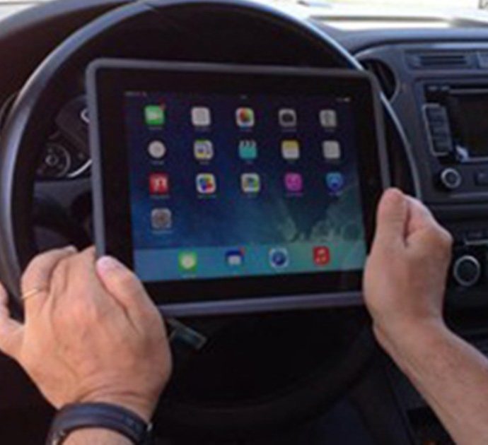 Fa smartworking con il tablet sul volante mentre guida in autostrada e non si accorge della polizia: multato
