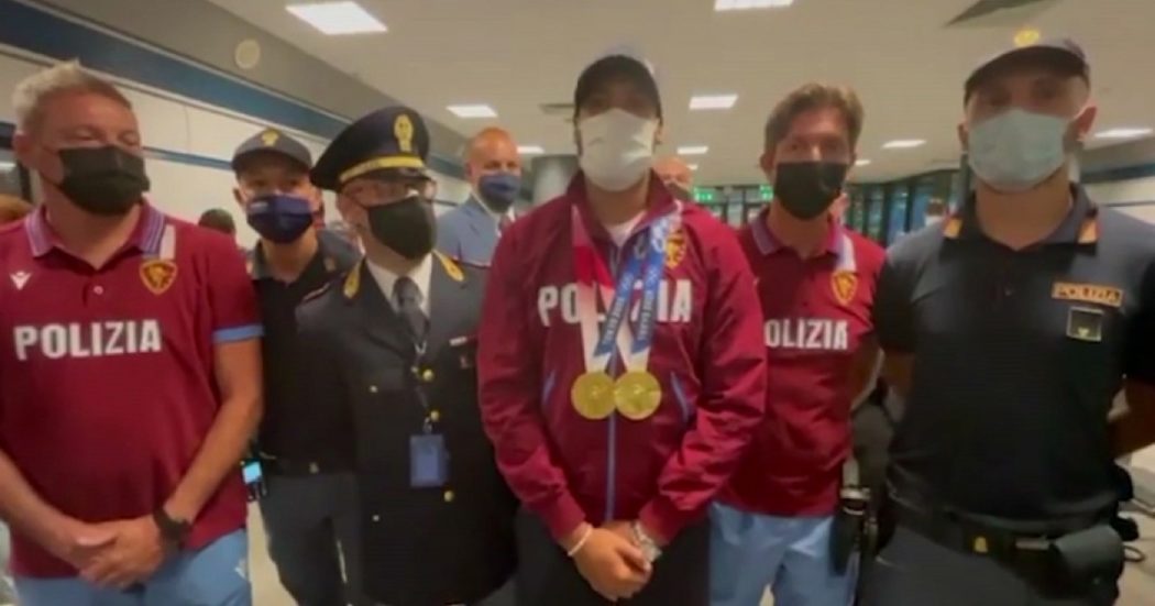 Marcell Jacobs atterra a Fiumicino dopo l’oro a Tokyo 2020: la polizia lo accoglie con un applauso. Lui: “I primi a credere in me dal 2013”