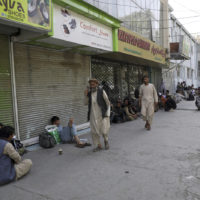 Afghans line a mostly shuttered market for hours to try to withdraw money from a nearby bank, in Kabul, Afghanistan, Sunday, Aug. 15, 2021. Officials say Taliban fighters have entered Kabul and are seeking the unconditional surrender of the central government. (AP Photo/Rahmat Gul)