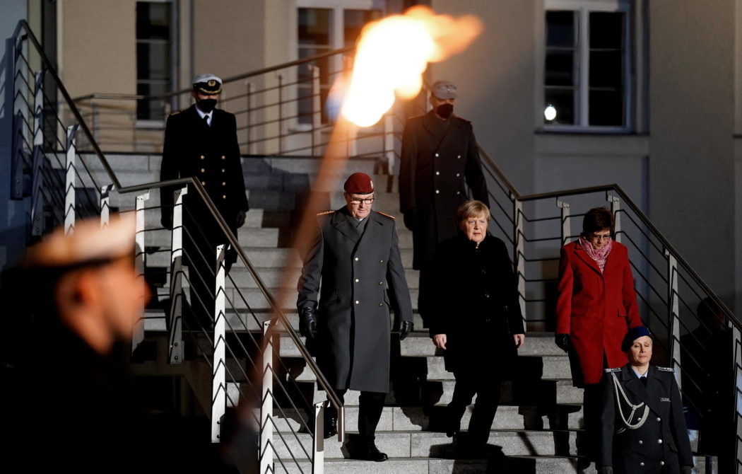 epa09617259 German Chancellor Angela Merkel (C) arrives during the military grand tattoo in her honor at the defense ministry in Berlin, Germany, 02 December 2021. Acting German Chancellor Angela Merkel receives on 02 December 2021, on the occasion of her farewell, a Grand Tattoo of the German Federal Armed Forces (Bundeswehr).  EPA/FRIEDEMANN VOGEL