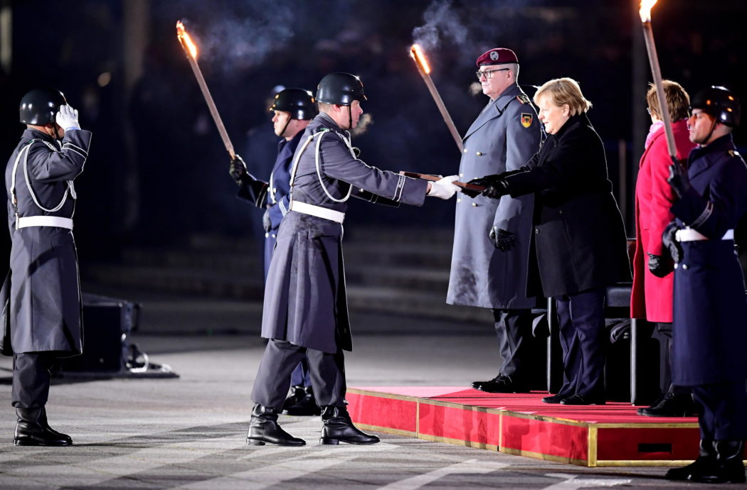 epa09617260 German Chancellor Angela Merkel (R) during the military grand tattoo in her honor at the defense ministry in Berlin, Germany, 02 December 2021. Acting German Chancellor Angela Merkel receives on 02 December 2021, on the occasion of her farewell, a Grand Tattoo of the German Federal Armed Forces (Bundeswehr).  EPA/FRIEDEMANN VOGEL