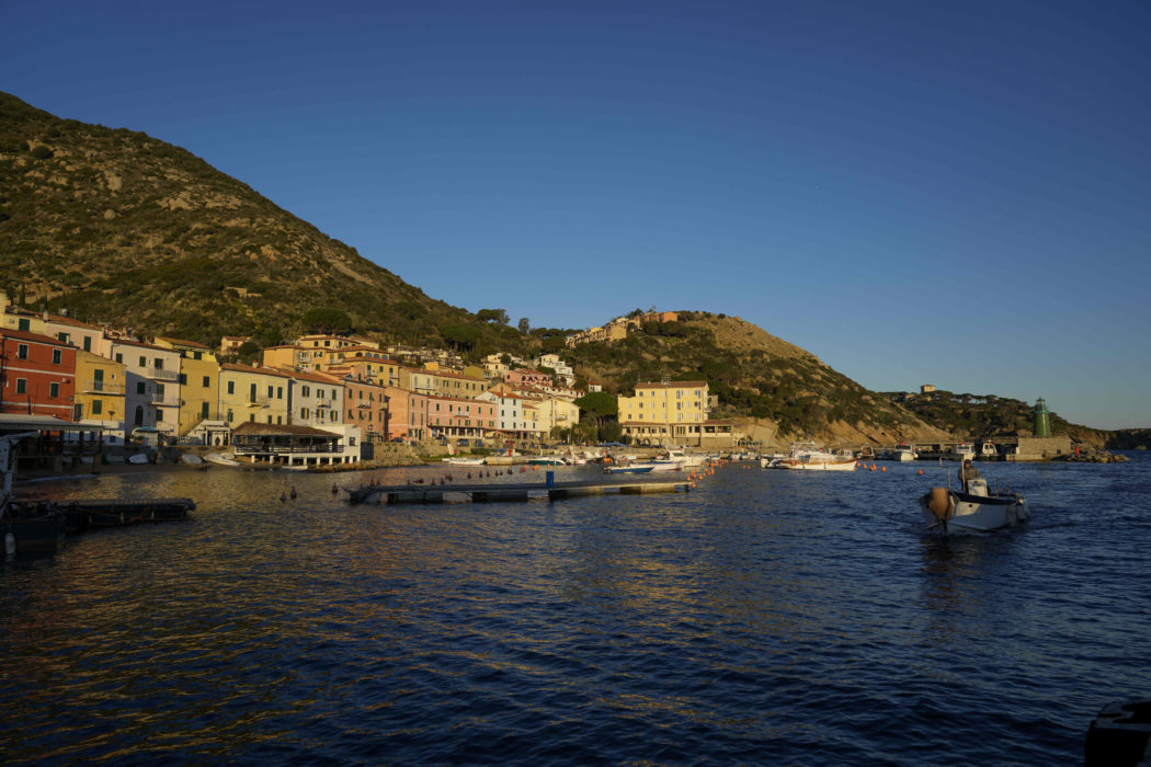 A fishing boat enters the port of the tiny Tuscan island of Isola del Giglio, Italy, Thursday, Jan. 13, 2022. Italy on Thursday is marking the 10th anniversary of the Costa Concordia cruise ship disaster with a daylong commemoration, honoring the 32 people who died but also the extraordinary response by the residents of Giglio who took in the 4,200 passengers and crew from the ship on that rainy Friday night and then lived with the Concordia carcass for another two years before it was hauled away for scrap. (AP Photo/Andrew Medichini)