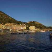 A fishing boat enters the port of the tiny Tuscan island of Isola del Giglio, Italy, Thursday, Jan. 13, 2022. Italy on Thursday is marking the 10th anniversary of the Costa Concordia cruise ship disaster with a daylong commemoration, honoring the 32 people who died but also the extraordinary response by the residents of Giglio who took in the 4,200 passengers and crew from the ship on that rainy Friday night and then lived with the Concordia carcass for another two years before it was hauled away for scrap. (AP Photo/Andrew Medichini)