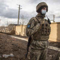A Ukrainian soldiers passes by houses in the village of Novoluhanske, Luhansk region, Ukraine, Saturday, Feb. 19, 2022. Separatist leaders in eastern Ukraine have ordered a full military mobilization amid growing fears in the West that Russia is planning to invade the neighboring country. The announcement on Saturday came amid a spike in violence along the line of contact between Ukrainian forces and the pro-Russia rebels in recent days. (AP Photo/Oleksandr Ratushniak)