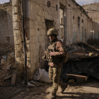 A Ukrainian serviceman walks inside a destroyed house near the frontline village of Krymske, Luhansk region, in eastern Ukraine, Saturday, Feb. 19, 2022. Ukrainian President Volodymyr Zelenskyy, facing a sharp spike in violence in and around territory held by Russia-backed rebels and increasingly dire warnings that Russia plans to invade, on Saturday called for Russian President Vladimir Putin to meet him and seek resolution to the crisis. (AP Photo/Vadim Ghirda)