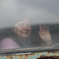 A woman waves from a train carriage to be evacuated to Russia, at the railway station in Debaltseve, the territory controlled by pro-Russian militants, eastern Ukraine, Saturday, Feb. 19, 2022. On Friday, separatist authorities in eastern Ukraine announced a mass evacuation of women, children and older adults to neighboring Russia. The moves have have fueled Western fears that Moscow could use the latest violence in eastern Ukraine as a pretext for an invasion. (AP Photo/Alexei Alexandrov)