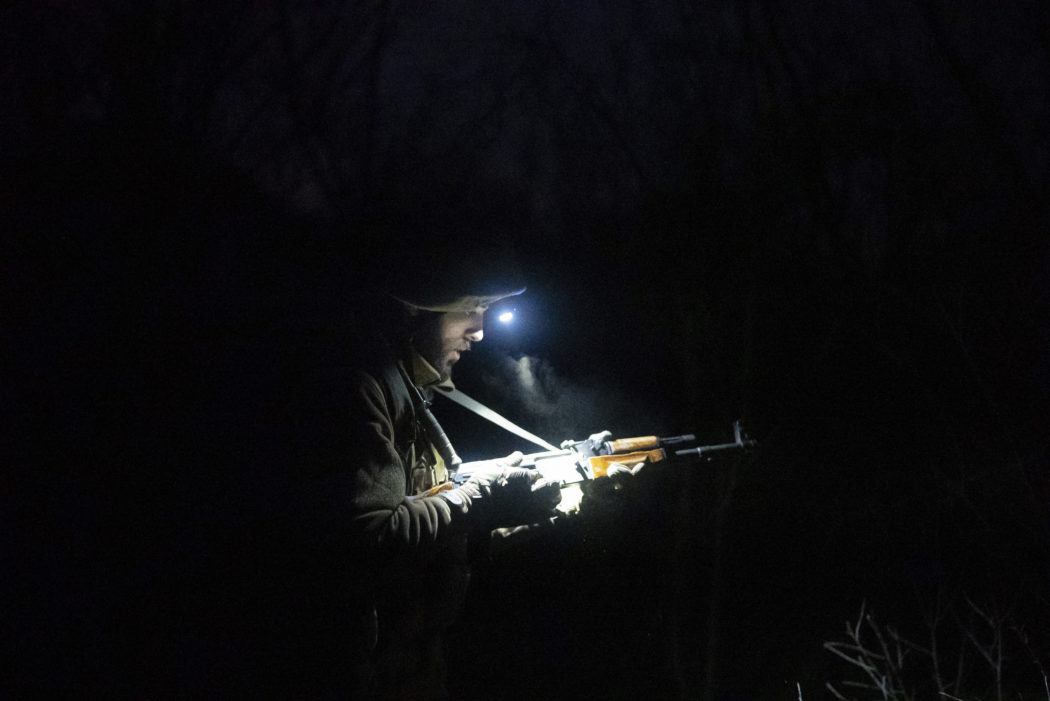 A Ukrainian serviceman lights his weapon on positions at the line of separation between Ukraine-held territory and rebel-held territory near Zolote, Ukraine, Saturday, Feb. 19, 2022. Ukrainian President Volodymyr Zelenskyy, facing a sharp spike in violence in and around territory held by Russia-backed rebels and increasingly dire warnings that Russia plans to invade, has called for Russian President Vladimir Putin to meet him and seek a resolution to the crisis. (AP Photo/Evgeniy Maloletka)