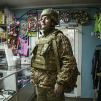 A Ukrainian soldier stands in a shop in the village of Novoluhanske, Luhansk region, Ukraine, Saturday, Feb. 19, 2022. Separatist leaders in eastern Ukraine have ordered a full military mobilization amid growing fears in the West that Russia is planning to invade the neighboring country. The announcement on Saturday came amid a spike in violence along the line of contact between Ukrainian forces and the pro-Russia rebels in recent days. (AP Photo/Oleksandr Ratushniak)