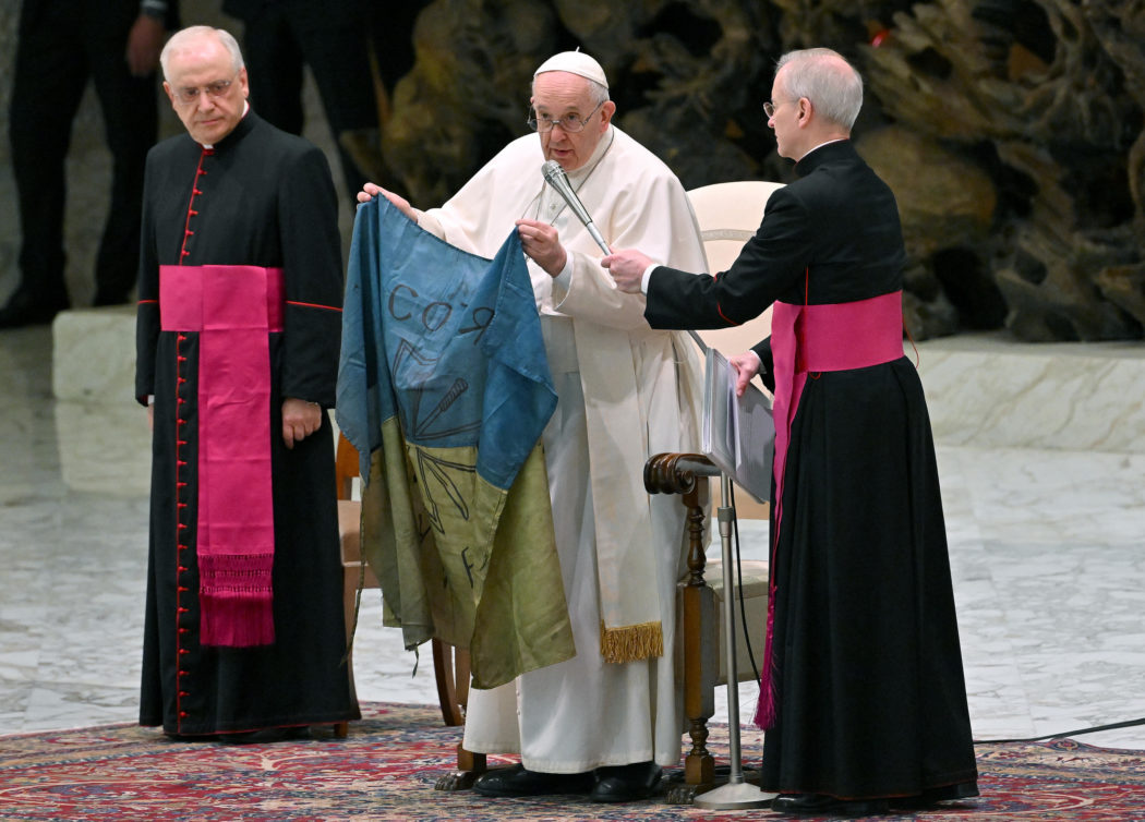 Pope Francis shows a flag of Ukraine that comes from the city of Bucha during the weekly general audience in Paolo VI Hall, Vatican City, 06 April 2022.  ANSA/ETTORE FERRARI