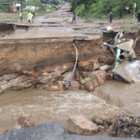 Stranded people stand in front of a bridge that was swept away in Ntuzuma, outside Durban, South Africa, Tuesday, April 12, 2022. Prolonged rains and flooding in South Africa’s KwaZulu-Natal province have claimed dozens of lives, according to local officials. (AP Photo)