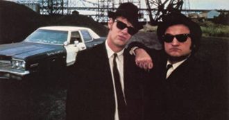 Copertina di The Blues Brothers, 42 anni dopo. Il regista John Landis: “Sul set avevamo soltanto venti paia di Rayban Wayfarer. Belushi li perdeva ovunque quando abbordava le ragazze”