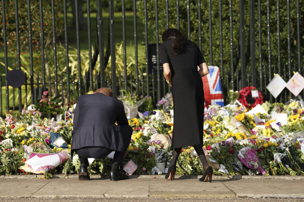 From left, Britain’s Prince Harry and Meghan, Duchess of Sussex view flowers left by members of the public, at Windsor Castle, following the death of Queen Elizabeth II on Thursday, in Windsor, England, Saturday, Sept. 10, 2022. (Kirsty O’Connor/Pool Photo via AP)