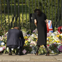 From left, Britain’s Prince Harry and Meghan, Duchess of Sussex view flowers left by members of the public, at Windsor Castle, following the death of Queen Elizabeth II on Thursday, in Windsor, England, Saturday, Sept. 10, 2022. (Kirsty O’Connor/Pool Photo via AP)