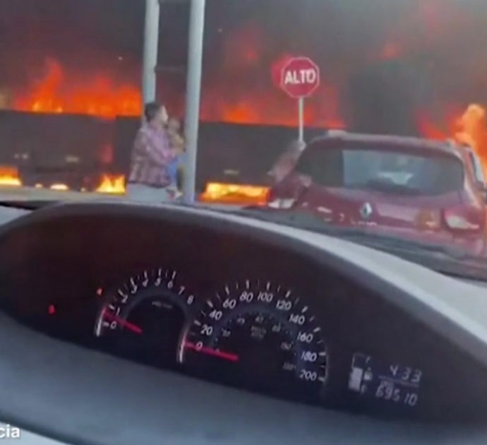 Enorme incendio avvolge ferrovia e case: il treno sfreccia su binari infiammati – Video