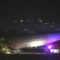 A firetruck stays beside a Korean Air Lines Co. plane after it overshot the runway at the Mactan-Cebu International Airport in Cebu, central Philippines early Monday Oct. 24, 2022. A Korean Air Lines Co. plane carrying 173 passengers and crew members overshot a runway while landing in bad weather in the central Philippines late Sunday and authorities said all those on board were safe. The airport is temporarily closed due to the stalled aircraft. (AP Photo/Juan Carlo De Vela)