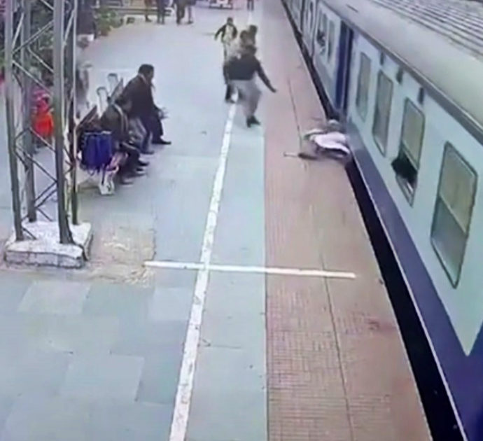 Sta per essere trascinato sotto un treno lungo i binari della stazione, vigilante lo salva – Video