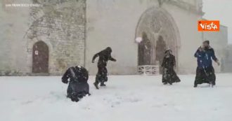 Copertina di Assisi, i frati della basilica di San Francesco giocano a palle di neve e disegnano angeli a terra: il video fa il giro dei social