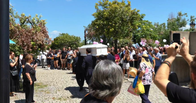 Funerali di Michelle Caruso, l’uscita del feretro tra gli applausi: palloncini bianchi e rosa in cielo