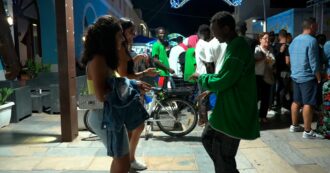Copertina di A Lampedusa migranti, isolani e turisti ballano insieme lungo le vie del centro: così la festa patronale diventa un momento di integrazione – Video