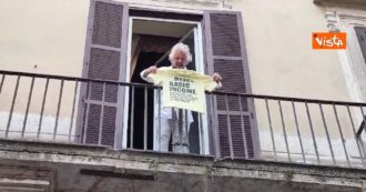 Copertina di Grillo a Roma mostra una maglia gialla sul reddito universale dal balcone della sede M5s