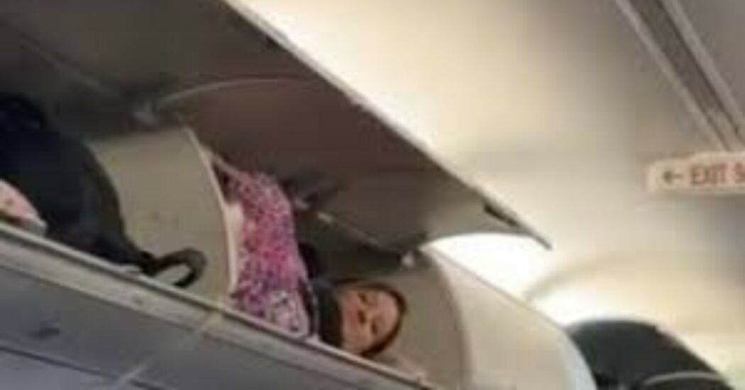 Passeggera si infila dentro la cappelliera dell’aereo e si sdraia tra i bagagli: la scena surreale diventa virale