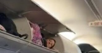 Passeggera si infila dentro la cappelliera dell’aereo e si sdraia tra i bagagli: la scena surreale diventa virale