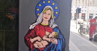 Copertina di “Santa Giorgia”, a Milano il murale con la premier che allatta con l’aureola europeista e le stelle dell’Ue – Video