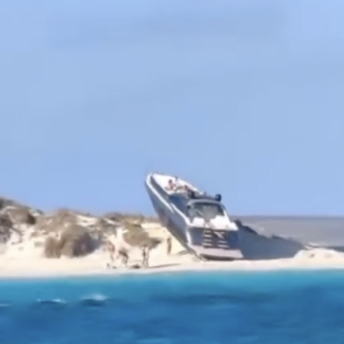 Uno yacht di lusso si arena su una spiaggia, turisti increduli