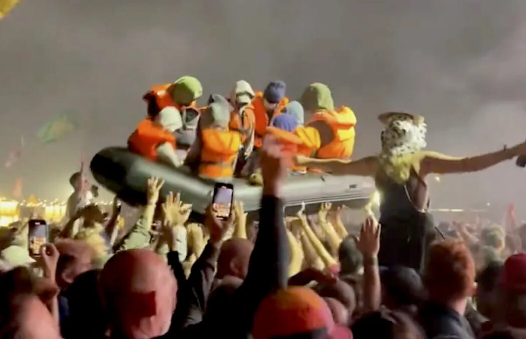 Il graffio di Bansky a Glastonbury 2024 con gommone e manichini di migranti sopra la folla. Per la prima volta due headliner donne SZA e Dua Lipa, show dei Coldplay – Il racconto