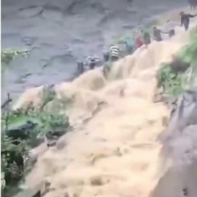 Piogge torrenziali travolgono i turisti in visita ad una cascata: loro formano una catena umana per resistere alla forza dell’acqua – VIDEO