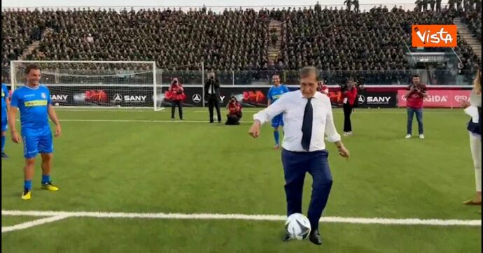 Copertina di Partita del cuore all’Aquila, l’allenatore La Russa palleggia in camicia e cravatta e segna un gol rima del match