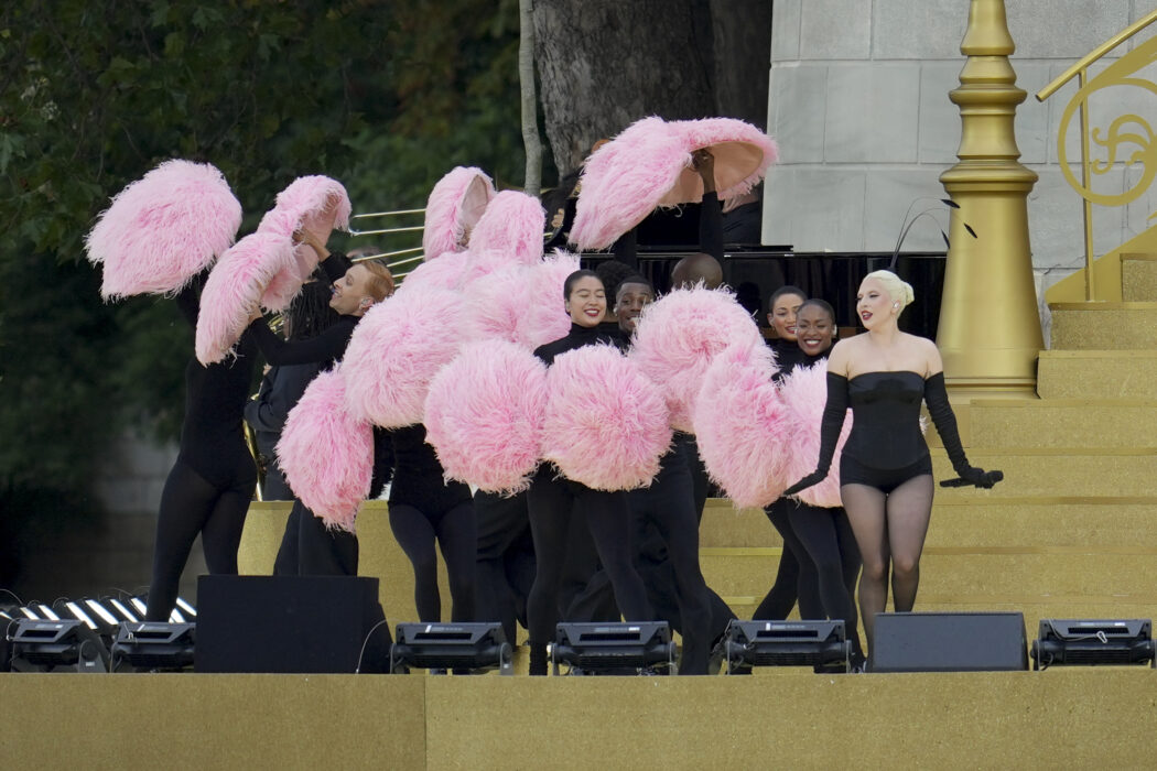 Olimpiadi 2024, Lady Gaga iconica circondata da pompon e piume rosa per l’omaggio al cabaret francese