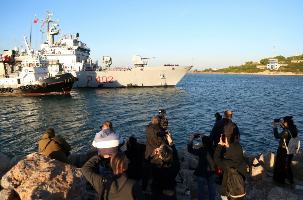 epa11661876 Journalists film and take pictures as an Italian navy boat carrying migrants intercepted in Italian waters arrives at Shengjin, Albania, 16 October 2024. Italy has begun sending migrants rescued in the Mediterranean to detention centers in Albania, where their asylum claims will be processed. The plan, finalized in February 2024, allows Italy to transfer up to 36,000 asylum seekers to Albania annually, with the goal of deterring migrants from attempting to reach Italy. While the Italian government and some EU leaders support the program, human rights groups criticize it for potentially putting migrants at risk and exposing them to rights violations.  EPA/MALTON DIBRA