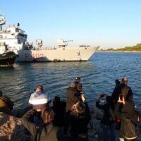 epa11661876 Journalists film and take pictures as an Italian navy boat carrying migrants intercepted in Italian waters arrives at Shengjin, Albania, 16 October 2024. Italy has begun sending migrants rescued in the Mediterranean to detention centers in Albania, where their asylum claims will be processed. The plan, finalized in February 2024, allows Italy to transfer up to 36,000 asylum seekers to Albania annually, with the goal of deterring migrants from attempting to reach Italy. While the Italian government and some EU leaders support the program, human rights groups criticize it for potentially putting migrants at risk and exposing them to rights violations.  EPA/MALTON DIBRA