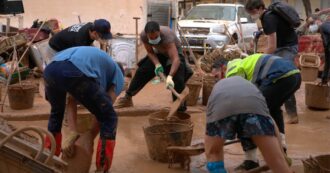 Copertina di Valencia, gli alluvionati organizzano una catena umana per rimuovere il fango da case e strade: “Stiamo soli, serve l’esercito”