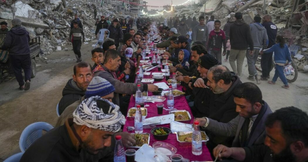 Il lungo tavolo tra le macerie e le case distrutte di Gaza: le immagini dell’Iftar per il primo giorno di Ramadan | FOTO