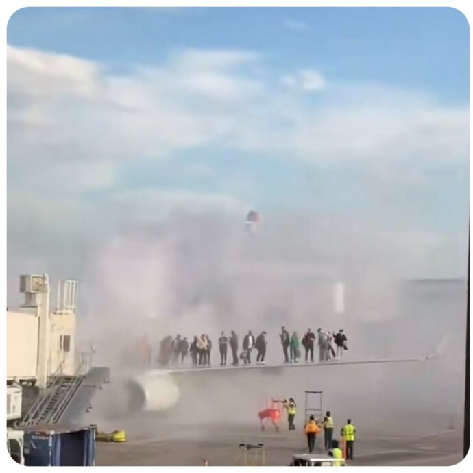 Vibrazioni ai motori, poi l’aereo prende fuoco durante l’atterraggio d’emergenza: passeggeri in piedi sull’ala del velivolo in fiamme – VIDEO