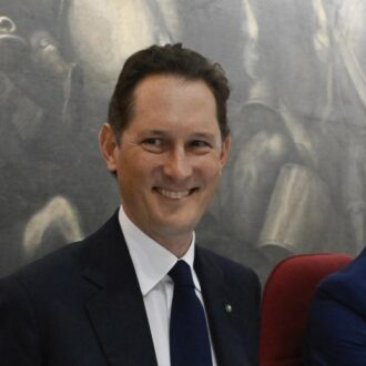 Copertina di Scudo col 'blasone' di ieri, zero sul domani: Elkann Re Sole in Parlamento. “Senza di noi l’auto in Italia sarebbe morta”