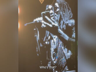 Copertina di Lenny Kravitz interrompe il concerto per parlare via telefono con una fan: “Perché non sei qui? Vieni”