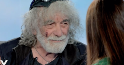 Copertina di “La cicatrice sul volto? Colpa di una motosega. Mi hanno ritirato la patente per il vino, ora ho detto stop”: Mauro Corona si racconta a Verissimo